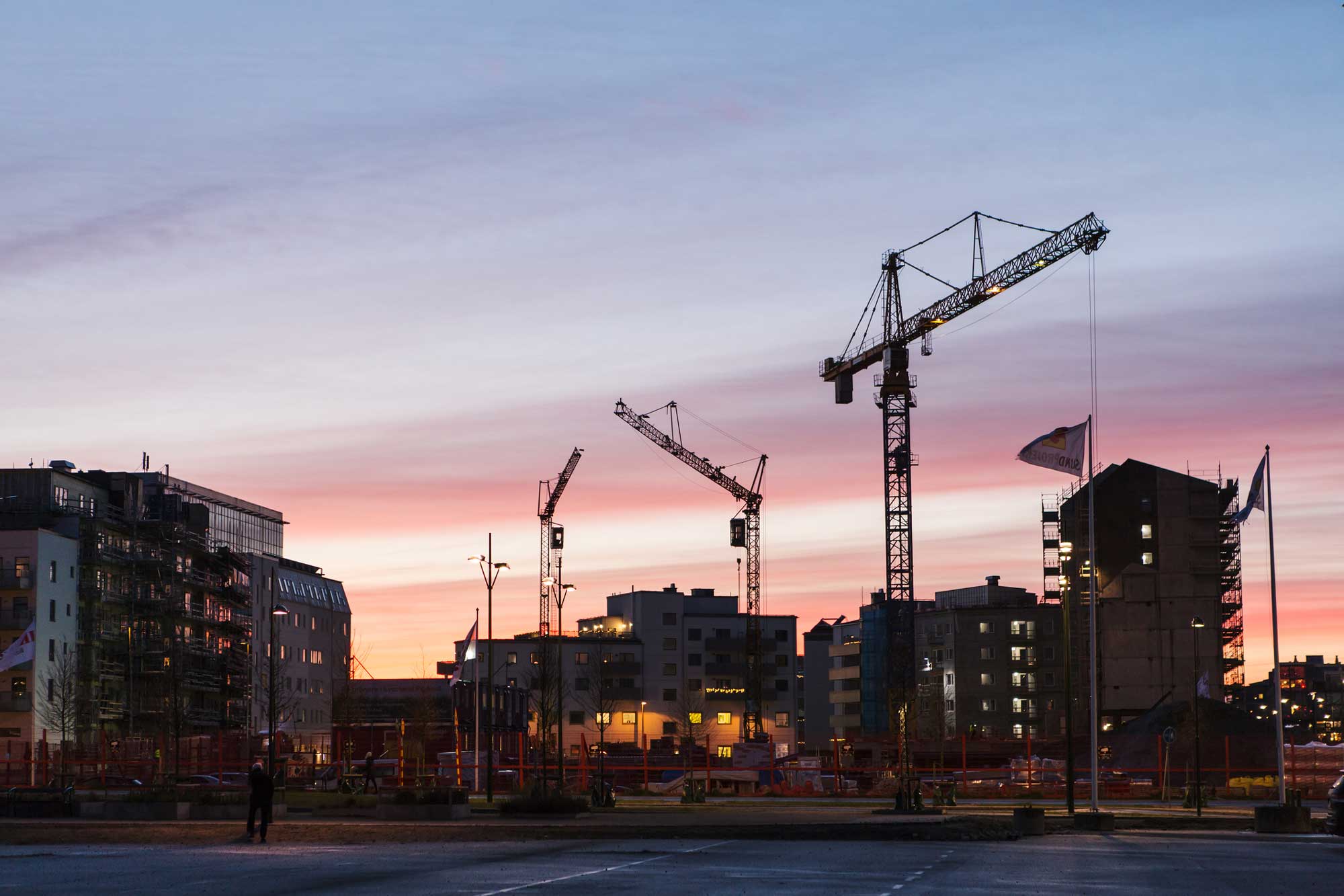 Byggakranar mot rosa himmel